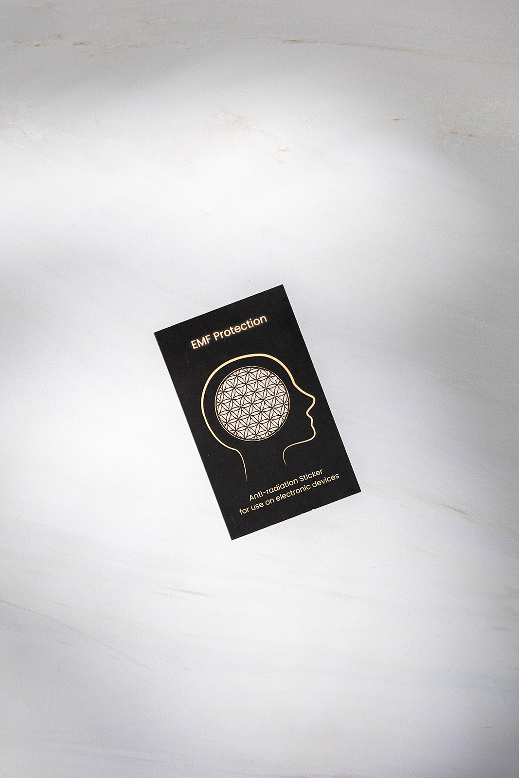 The EMF protection card shown on a pale surface.